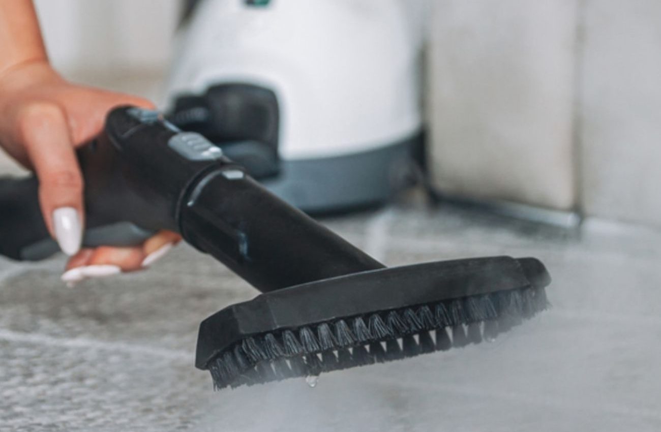 A steam cleaner is used by a person on a tile floor, illustrating a Houston, TX service focused on prevention and protection.